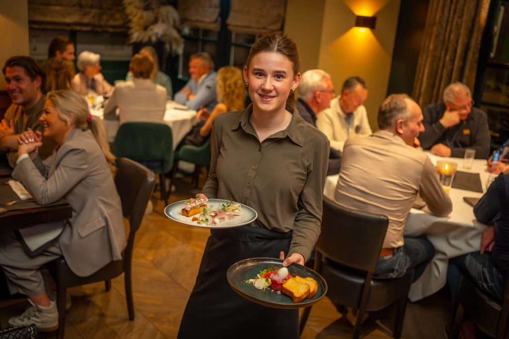 Medewerker bediening serveert gerechten in sfeervol restaurant van Bistro T-Bone voor vacature bediening