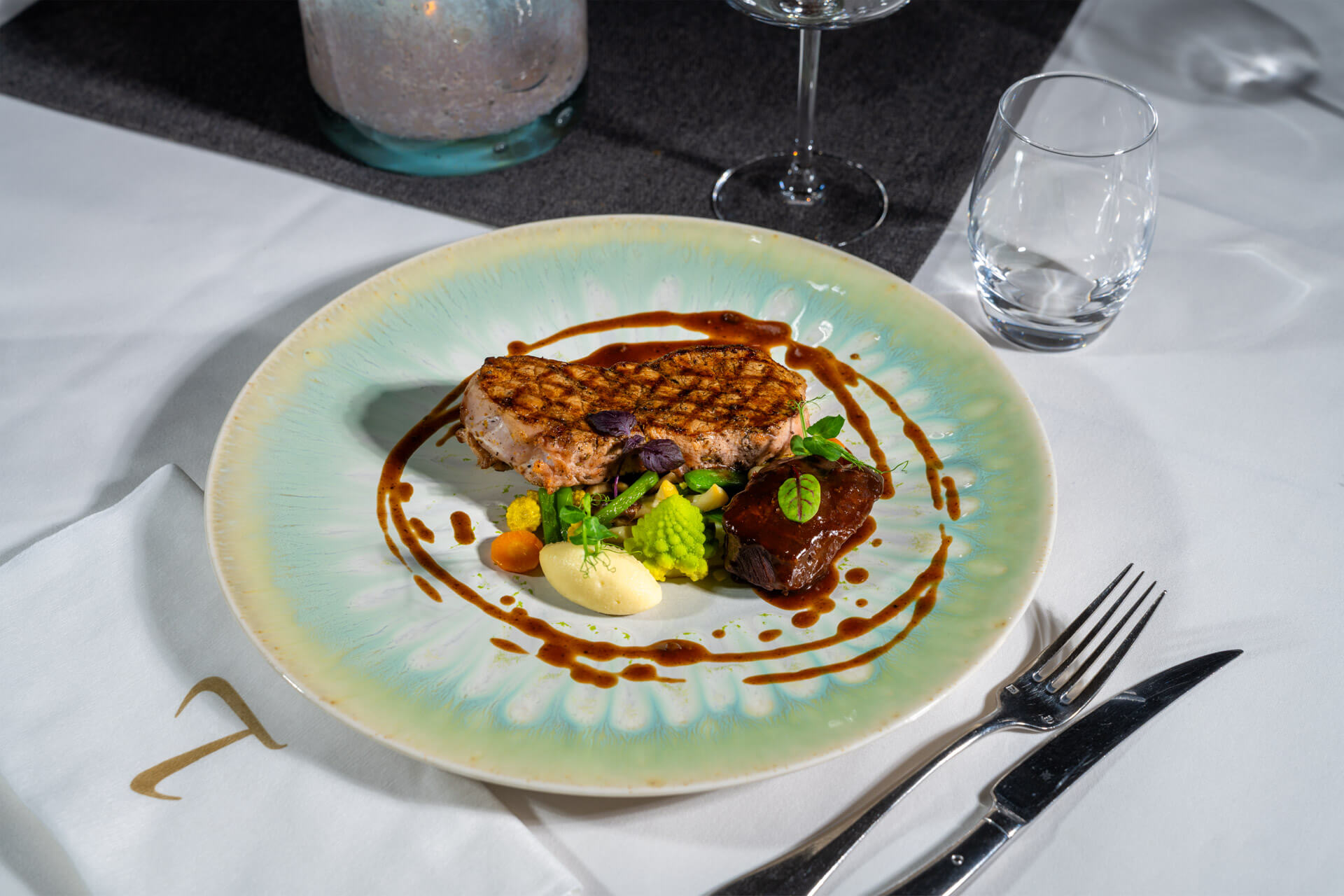 T-bone kalfsentrecote met varkenswang, seizoensgroenten en jus geserveerd op luxe bord bij Bistro T-Bone
